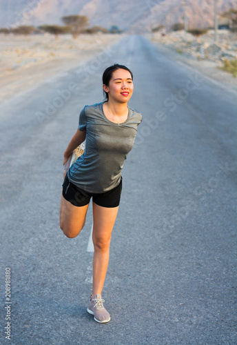 Girl stretching on the road before running © creativefamily