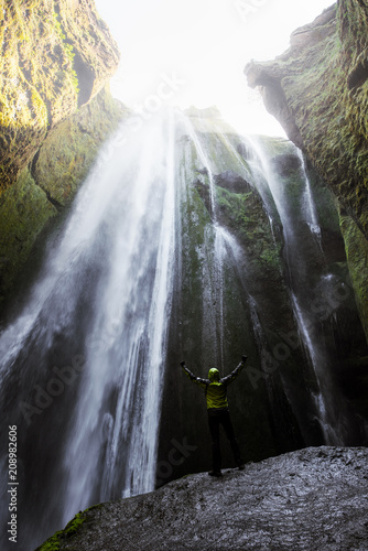 Man in the cave near the Gljufrabui waterfall, Iceland, Europe