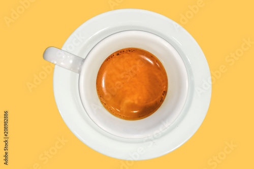 Fresh creamy espresso caffee in white cup isolated on yellow background