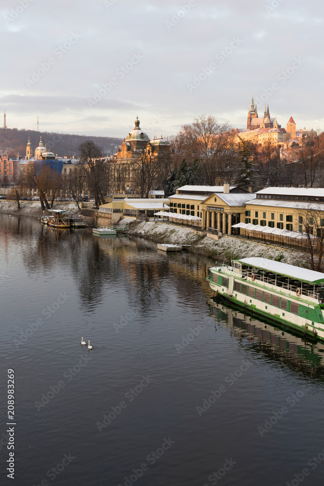 Obraz premium Sunny snowy early morning Prague Lesser Town with gothic Castle above River Vltava, Czech republic