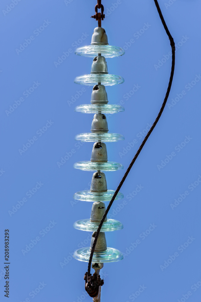 Electrical insulators made of hardened glass, top view, blue background, vertical photo.