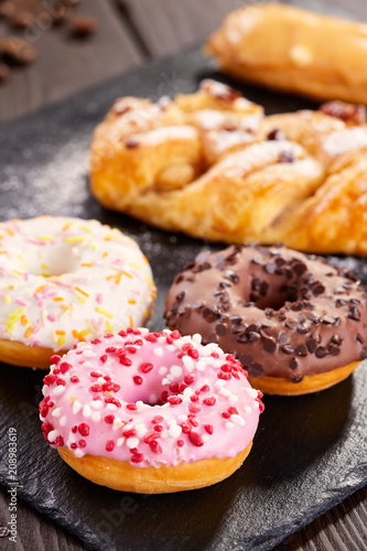 Assorted donuts with pink glazed, chocolate frosted and sprinkles