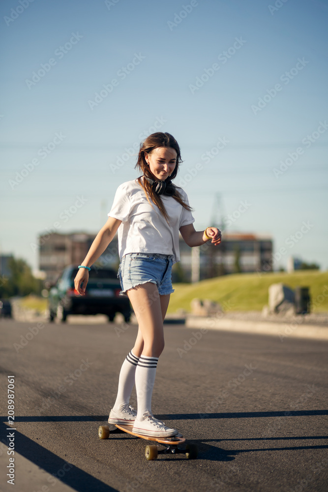 Girl in white stockings riding on longboard