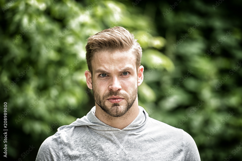 Handsome in style. Guy bearded attractive cares about appearance. Man bristle serious face, green nature background, defocused. Metrosexual concept. Man beard unshaven guy looks handsome and cool Handsome in style. Guy bearded attractive cares about appearance. Man bristle serious face, green nature background, defocused. Metrosexual concept. Man beard unshaven guy looks handsome and cool