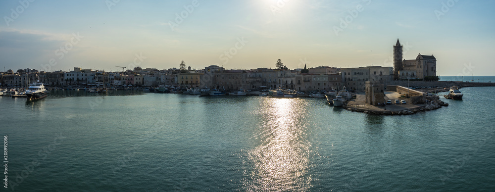 Seascape of Trani harbour at sunset, with the old town and the Cathedral dedicate to Saint Nicholas, Apulia, Italy
