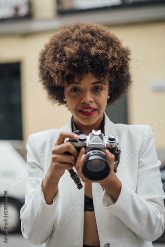 Female Photographer Holding an Old Analog Camera © karrastock