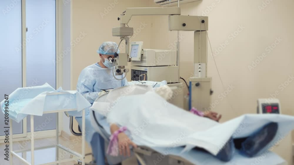 Man doctor is making operation on a head of human. Patient is under anesthesia on a surgical table, using modern equipment and computers Man doctor is making operation on a head of human. Patient is under anesthesia on a surgical table, using modern equipment and computers
