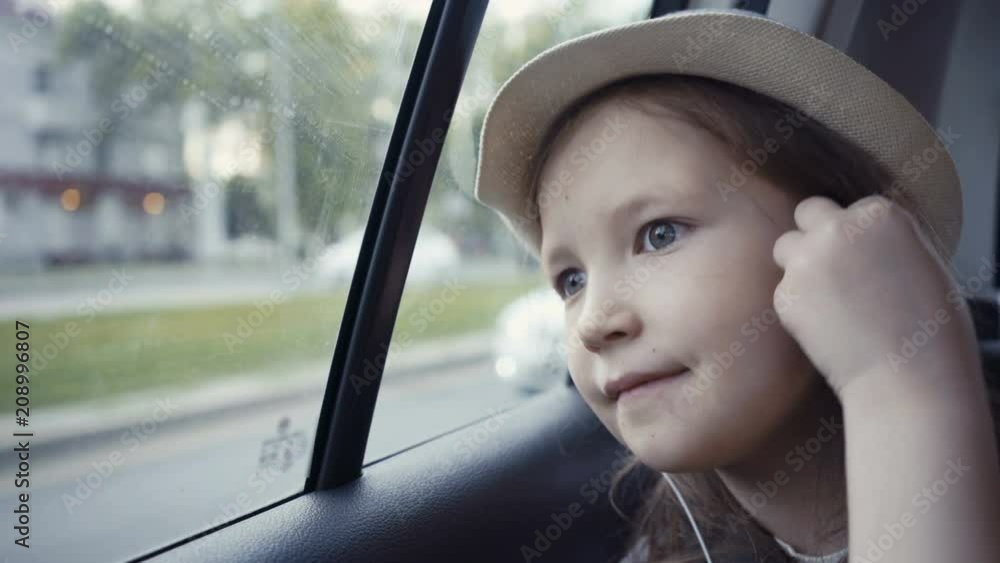 Little girl looking out from car window at sunny day. Little girl looking out from car window at sunny day.