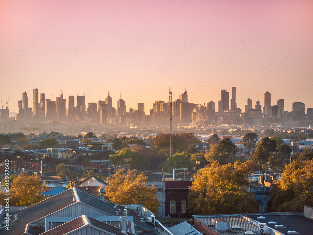 Naklejka premium Wieżowce w CBD w Melbourne w porannej mgle. Podwyższony widok na domy mieszkalne na zachodnich przedmieściach i nowoczesne budynki w mieście. Footscray, VIC Australia.