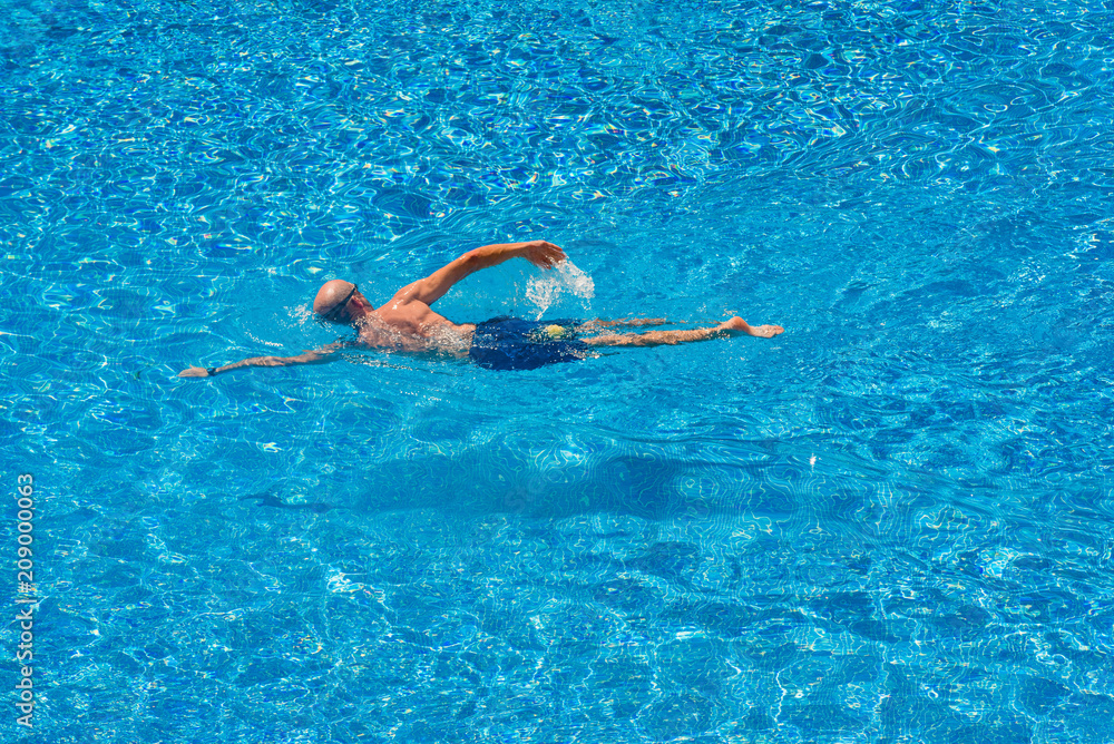 Man swimming in a pool in summer