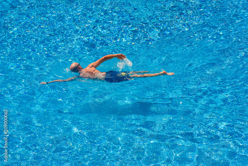 Man swimming in a pool in summer