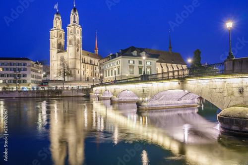 Beautiful view of historic city center of Zurich with famous Grossmunster Church and Munsterbucke crossing river Limmat on Twilight time in summer, Canton of Zurich, Switzerland