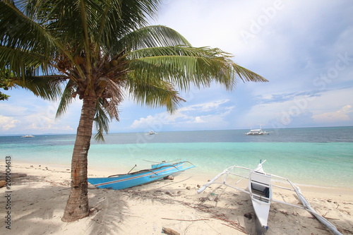 Colorful wooden boats on a beautiful tropical island white sandy beach