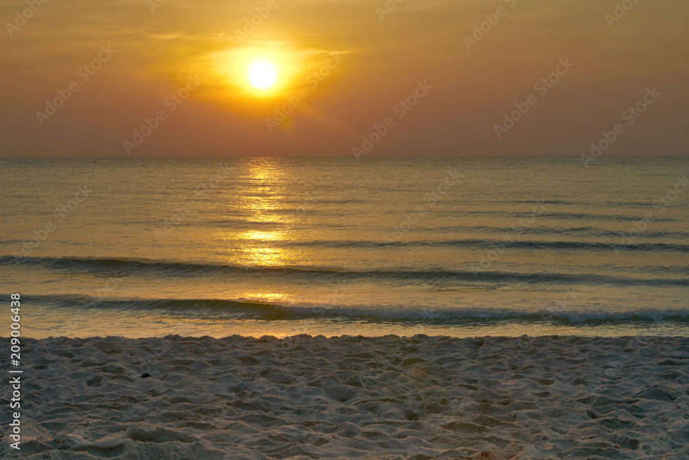 Golden sun and sand beach and waves in the sea