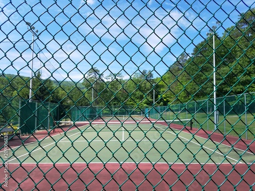 metal fence and green and red tennis court photo