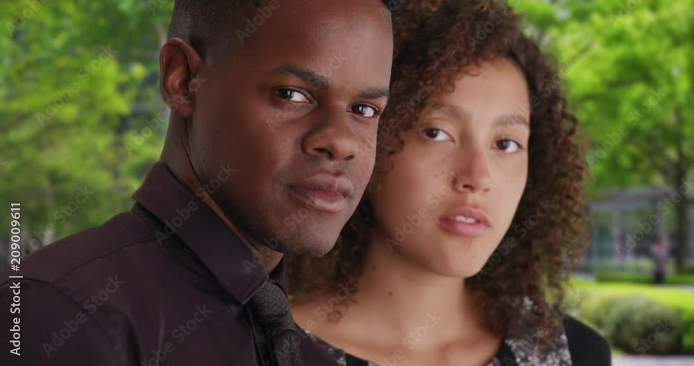 Portrait of young successful black male and female smiling confidently at camera, Close up of millennial business people standing outdoors, 4k Portrait of young successful black male and female smiling confidently at camera, Close up of millennial business people standing outdoors, 4k