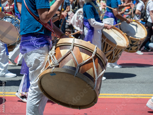 Photography Mexican marching band beats on drums while walking down streets of Carnaval fest