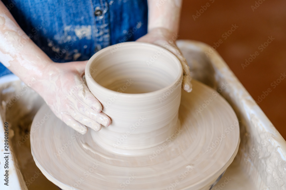 pottery handicraft skills. traditional art of creating ceramics. little crafty child potter modeling and shaping clay on turning wheel pottery handicraft skills. traditional art of creating ceramics. little crafty child potter modeling and shaping clay on turning wheel