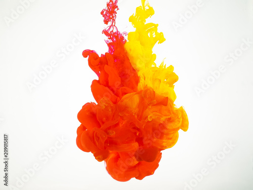 Abstract background of yellow and red splash of ink in water. Cloud of silky ink in water isolated on white background. Ink swirling in water. The paint dissolving into water
