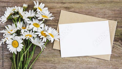 Fototapeta Naklejka Na Ścianę i Meble -  blank white greeting card and envelope with chamomile flowers
