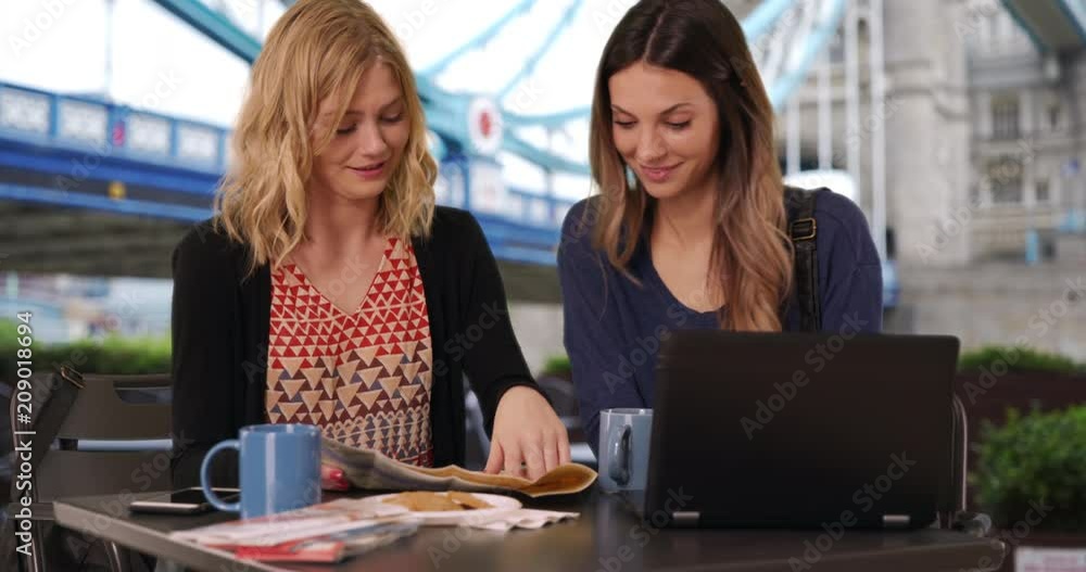 Close-up of couple friends looking at travel map and using laptop computer in front Tower Bridge in London, England, Two beautiful girlfriends looking at map and laptop near landmark in UK, 4k Close-up of couple friends looking at travel map and using laptop computer in front Tower Bridge in London, England, Two beautiful girlfriends looking at map and laptop near landmark in UK, 4k