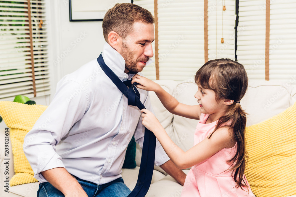 Obraz premium Father with little daughter having fun and playing together on the sofa at home.Love of family and father day concept