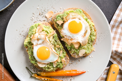 Delicious toasts with avocado and eggs on plate