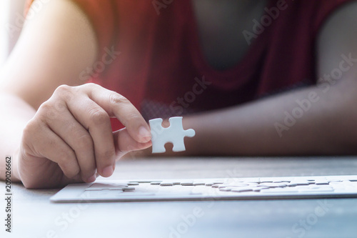 Close up shot hands of woman holding paper jigsaw puzzle select focus shallow depth of field