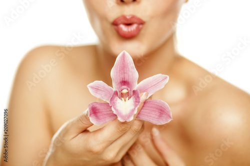 beautiful young woman hold an orchid on white background