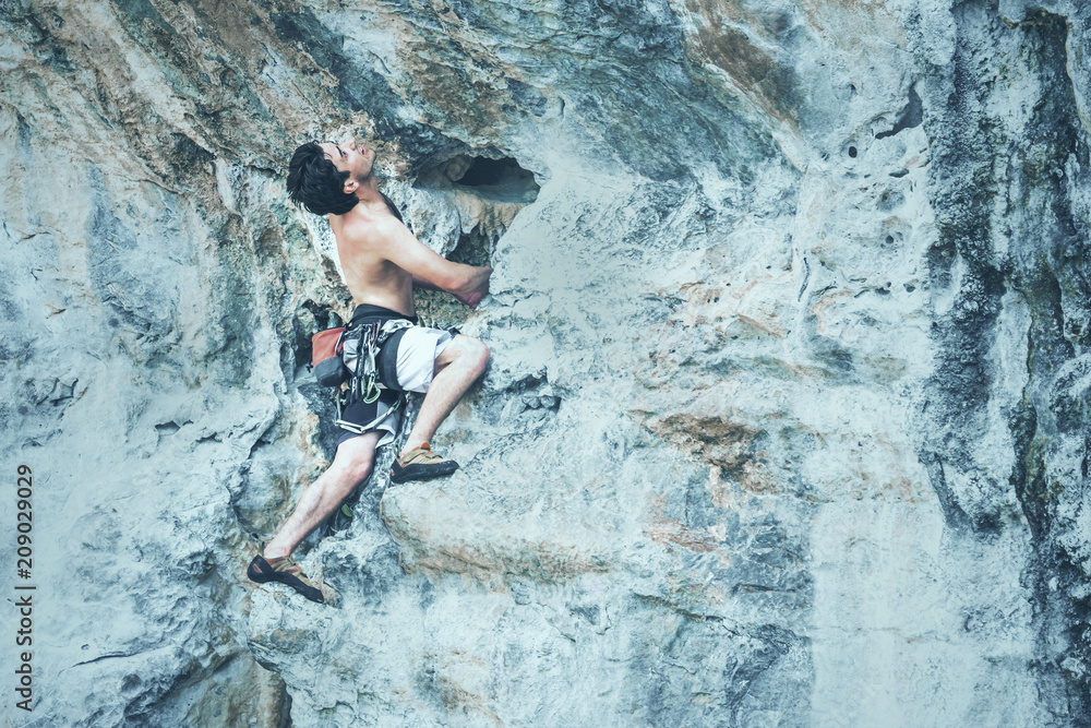 A man climbs on a cliff. Toned