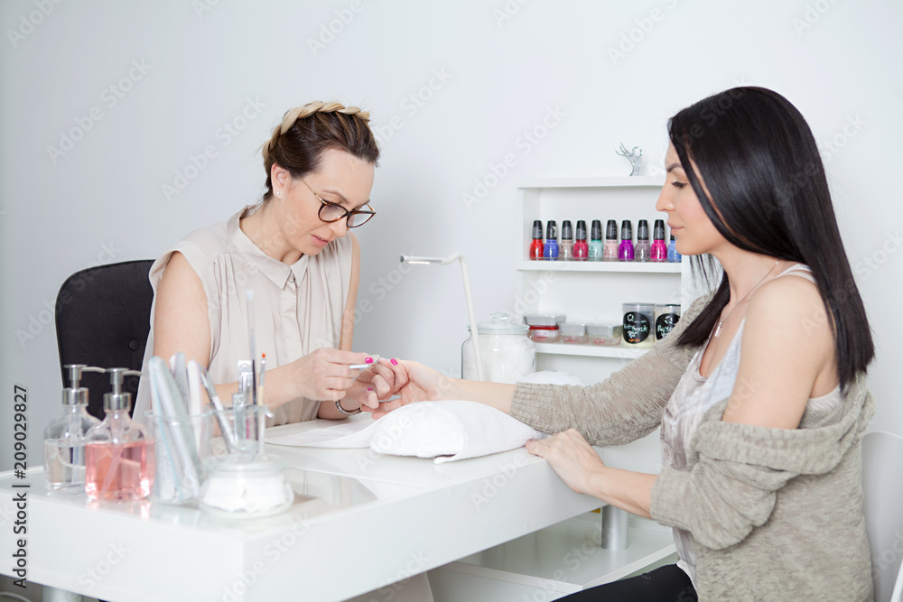 Premium Photo | Woman receive care service by professional beautician  manicure at spa centre nail beauty salon use nail file for glazing treatment  manicurist make nail customer to beautiful body care spa