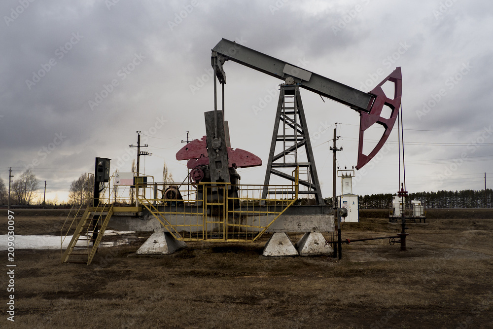 The beam pumping unit is homework, sunset in oil field. Oil pump oil rig energy industrial machine for petroleum. The pumping unit as the pump installed on a well. Equipment of oil fields. The beam pumping unit is homework, sunset in oil field. Oil pump oil rig energy industrial machine for petroleum. The pumping unit as the pump installed on a well. Equipment of oil fields.