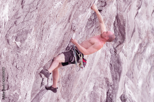 Climber climbs the cliff. Toned