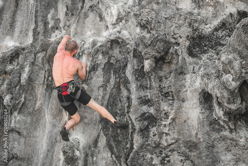 A man without safety equipment climbs the rock