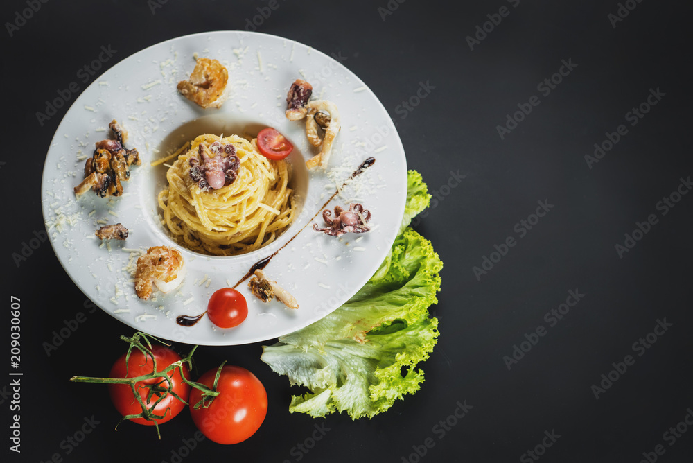 Tasty pasta with seafood on black background Tasty pasta with seafood on black background