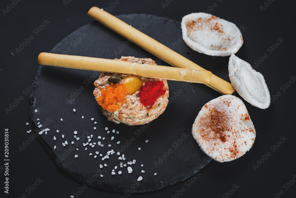 Tartar with caviar and bread sticks on black Tartar with caviar and bread sticks on black