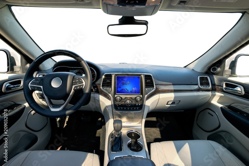 Car dashboard and steering wheel. The interior of a modern luxury SUV type car.Kokpit trimmed with leather and decorated with precious wood © Mike Mareen