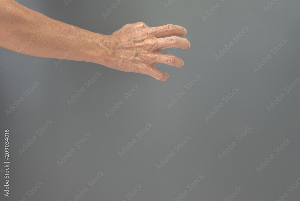 Expression gesture of an elderly man's hand on a gray background Expression gesture of an elderly man's hand on a gray background