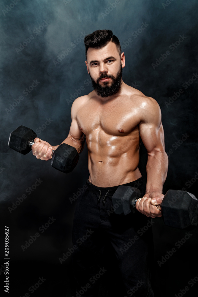 athletic muscular man doing exercises with dumbbells.