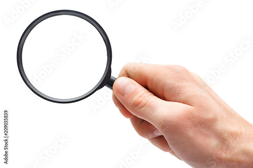 Man's hand with magnifying glass.