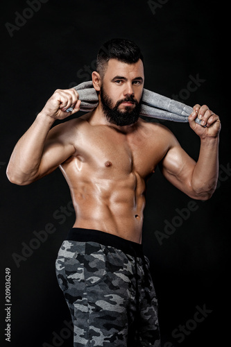 bodybuilder with towel on black background