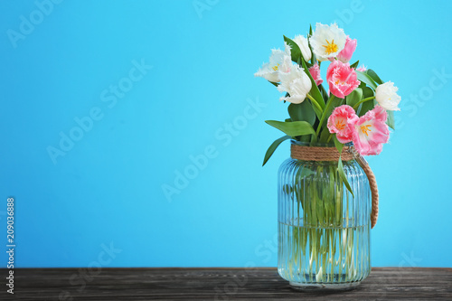 Wallpaper Mural Vase with beautiful tulips on  wooden table against color background Torontodigital.ca