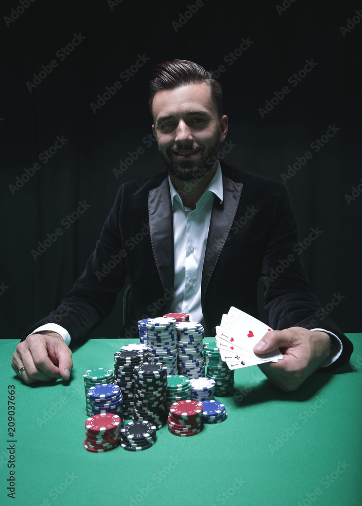 Happy poker player winning and holding a pair of aces Happy poker player winning and holding a pair of aces