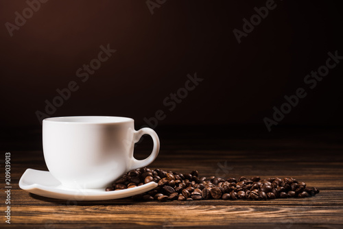 close-up shot heap of coffee beans cup on rustic wooden table