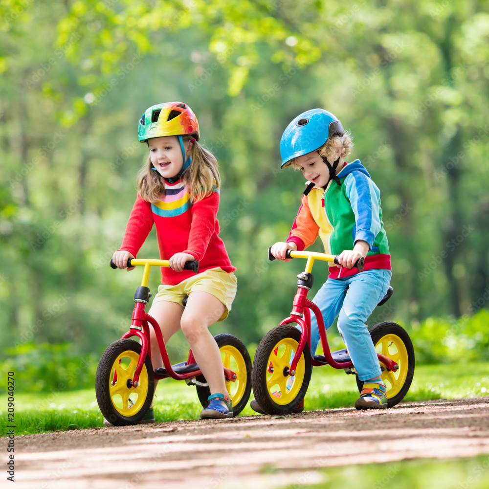 Fototapeta premium Kids ride balance bike in park