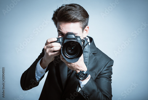Professional photographer taking picture with DSLR camera. 