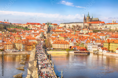 View of Charles Bridge, Prague Castle and Vltava river in Prague, Czech Republic from above. Nice sunny summer day with blue sky and clouds. Famous landmarks in Europe. photo