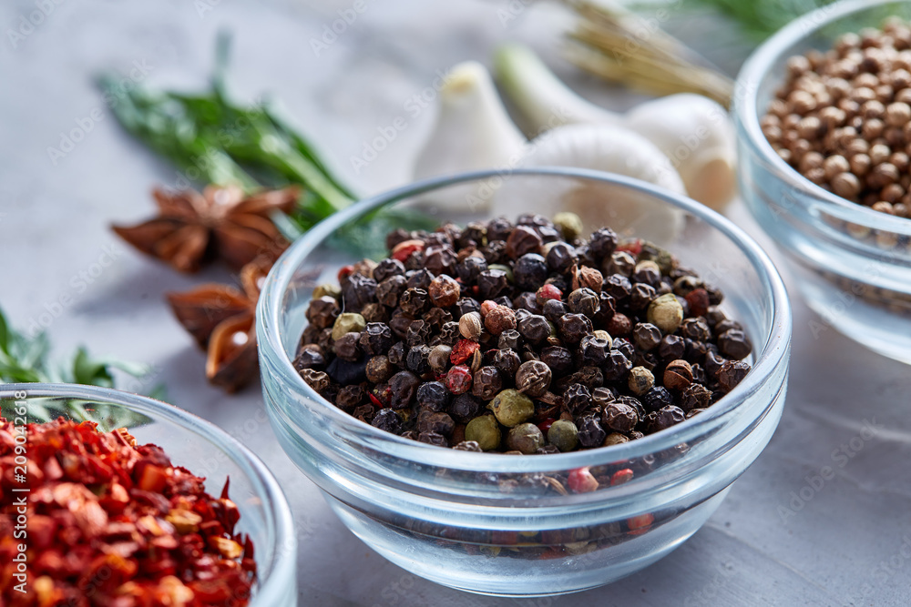 Transparent glass bowls with peppercorns and dried chilly among exotic spicies, close-up, top view, selective focus. Transparent glass bowls with peppercorns and dried chilly among exotic spicies, close-up, top view, selective focus.