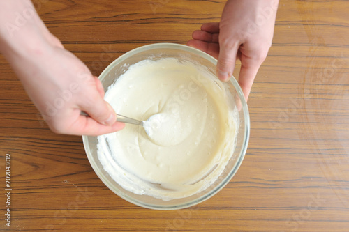 Prepare the dough for a homemade cake, hand knead the dough in a bowl