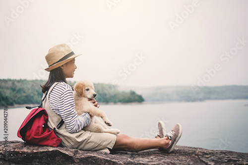 Happy girl playing with little dog in nature background, travel on holiday color of vintage tone and soft focus
